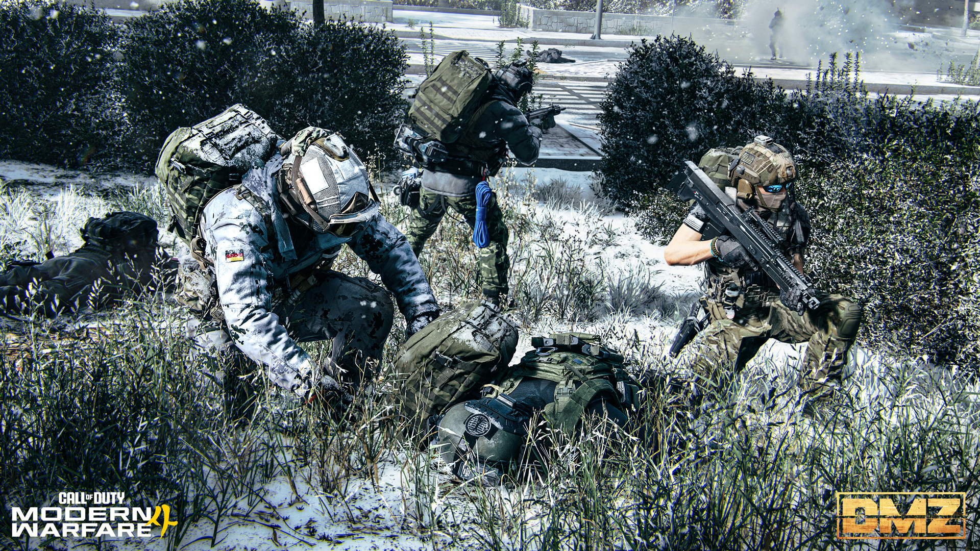 Three armed soldiers take cover in snowy grass and bushes while one searches a fallen soldier's backpack.