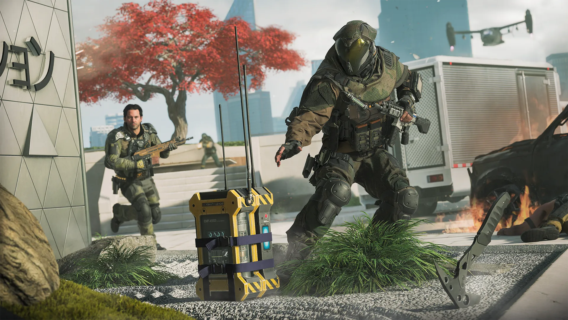 Armed soldiers in tactical gear move through a modern urban plaza as one of them reaches for a large EMP device on the ground, with a red-leafed tree, burning car, and tiltrotor aircraft visible in the background.