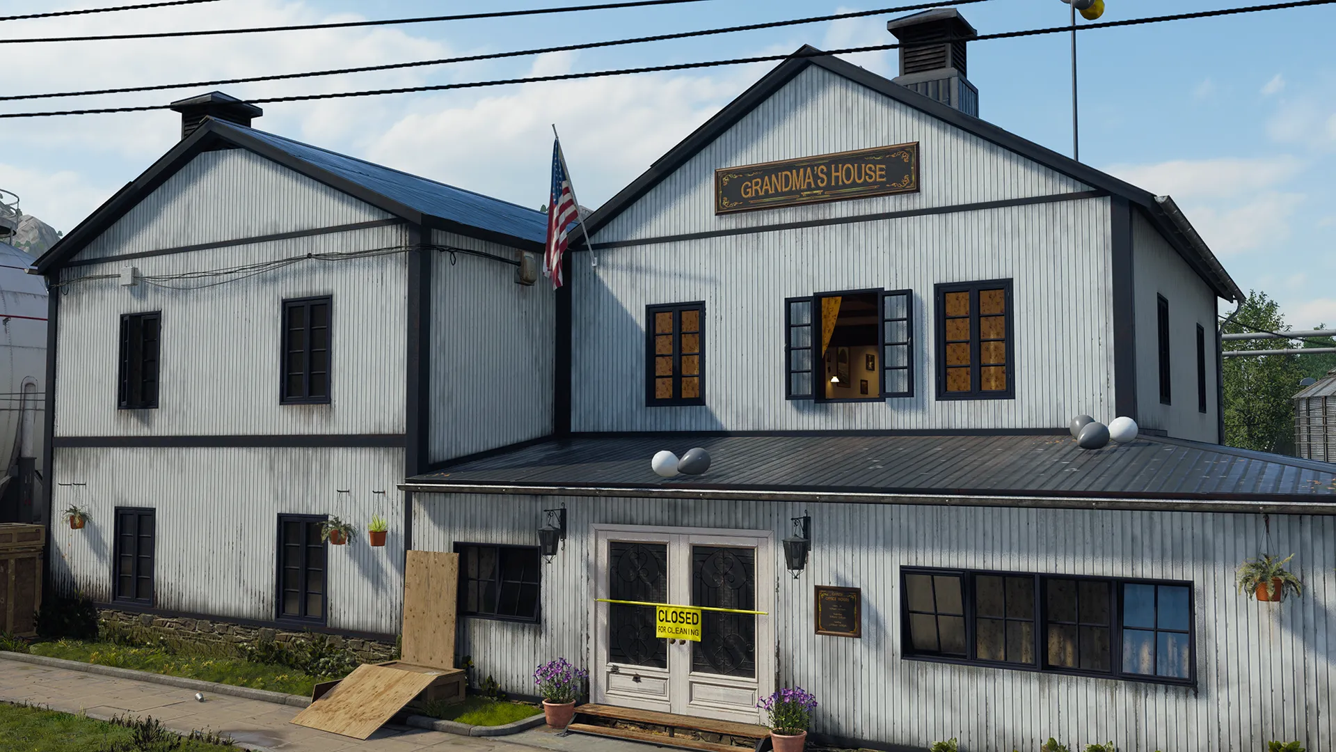 A two-story white wooden building labeled “Grandma’s House” faces a quiet street, with boarded sections, potted flowers, and a yellow “Closed” sign taped across the front doors. Decorative string lights and balloons overhead suggest a recently ended event in this rural town setting.