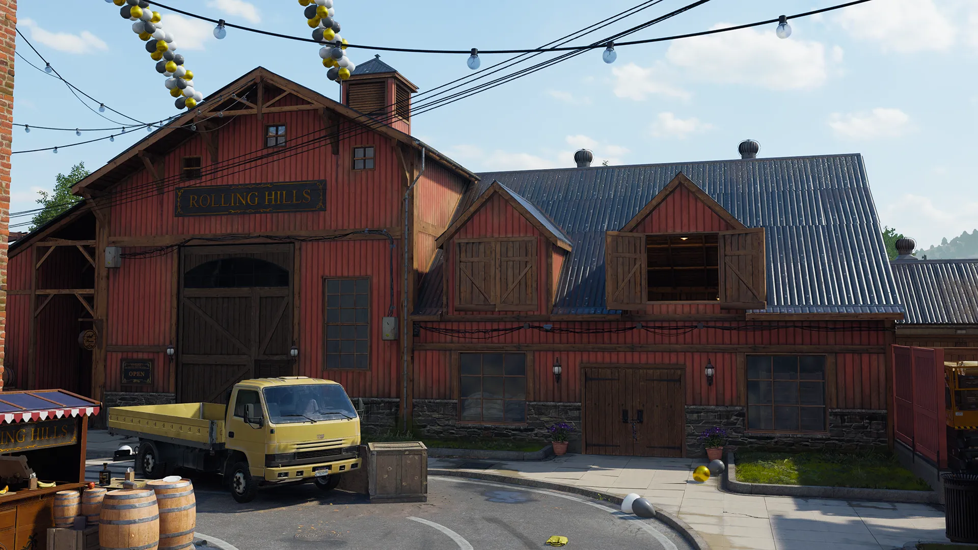 A red barn-style building marked “Rolling Hills” dominates the view, with wooden doors, upper loft openings, and a small yellow truck parked out front. Barrels, crates, and balloons emphasize the distillery setting and small-town atmosphere.