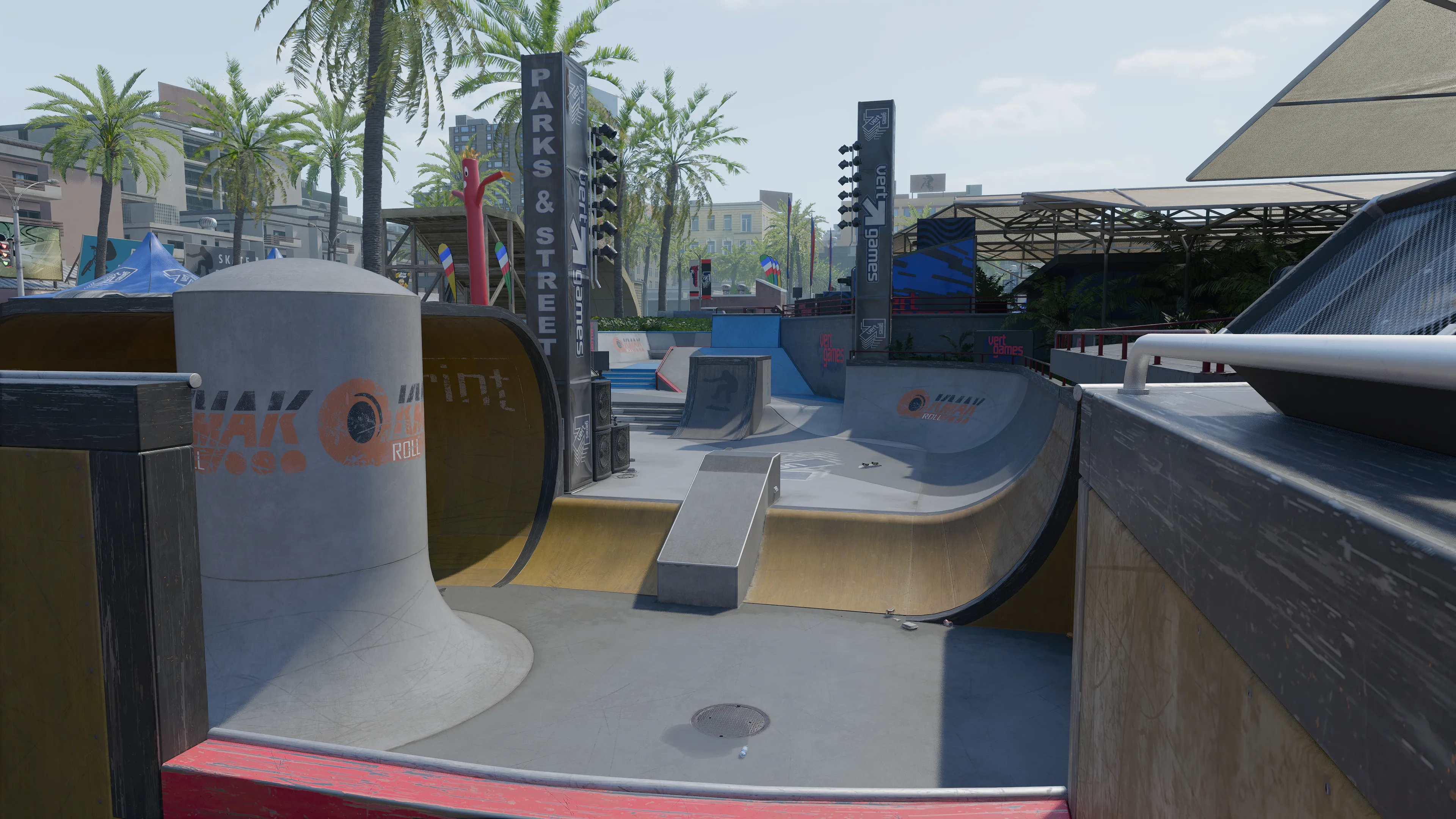 A skate park bowl with ramps and rails beneath “Parks & Street” and Vert Games signage surrounded by palm trees and event structures.