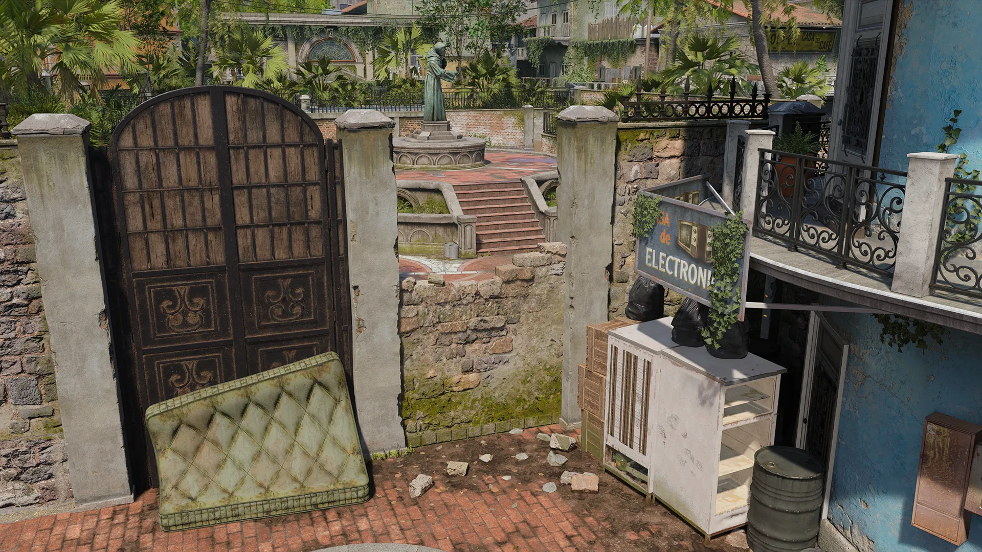 Worn courtyard entrance with iron gate, stone walls, and a statue visible beyond.