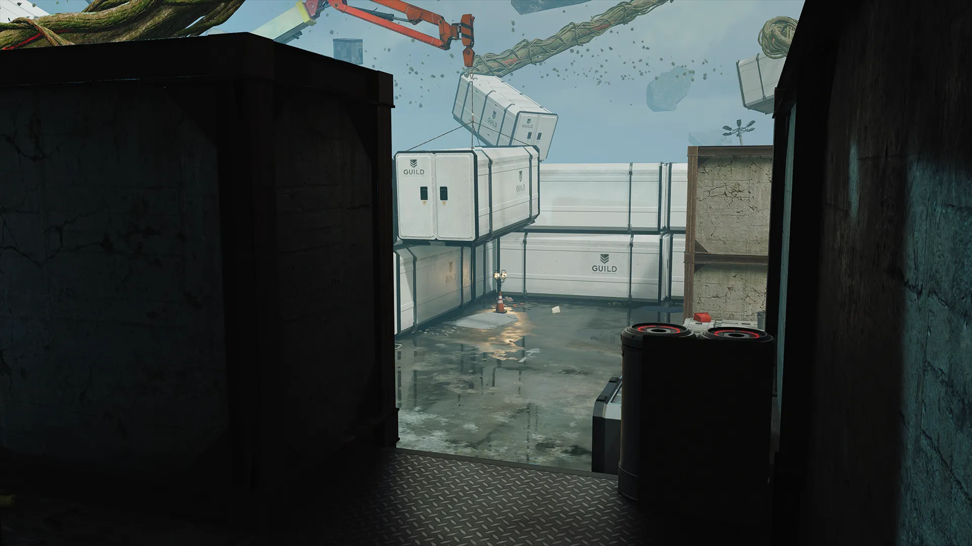 View from a dark corridor looking out to stacked white cargo containers in a rain-soaked yard.