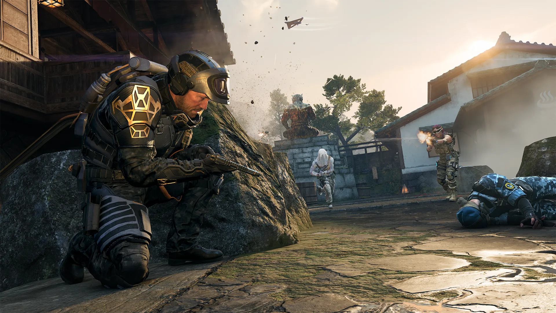 Soldier crouches behind a rock aiming a pistol as others fire and one lies on the ground in a courtyard.