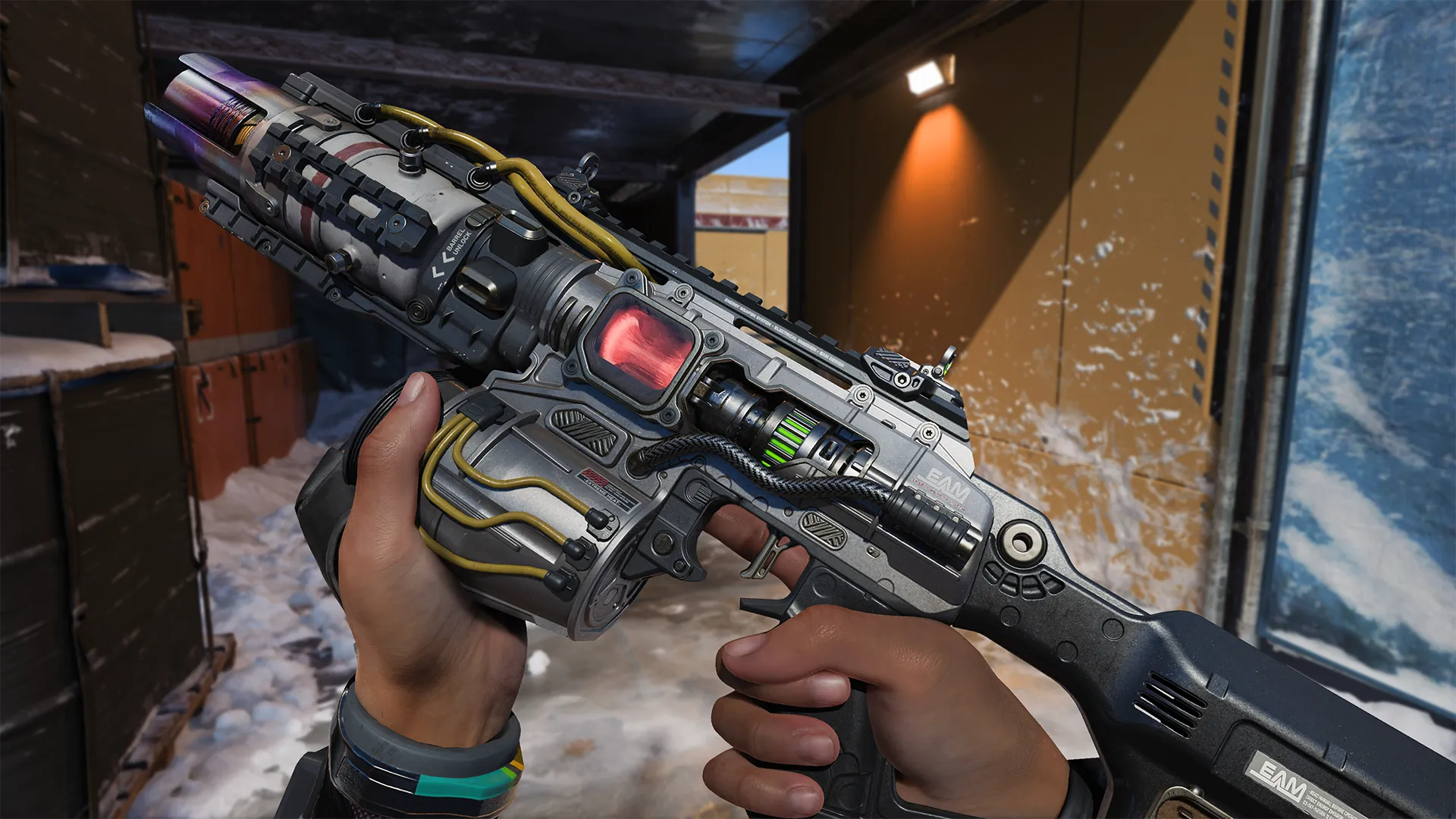 Hands holding a futuristic rifle with glowing red and green parts inside a snowy corridor.